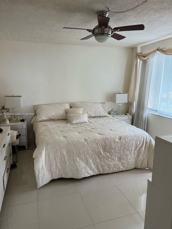 345 N Fort Lauderdale Beach Blvd Unit 202, Fort Lauderdale, FL 33304 - bedroom with ceiling fan, a textured ceiling, and light tile patterned flooring