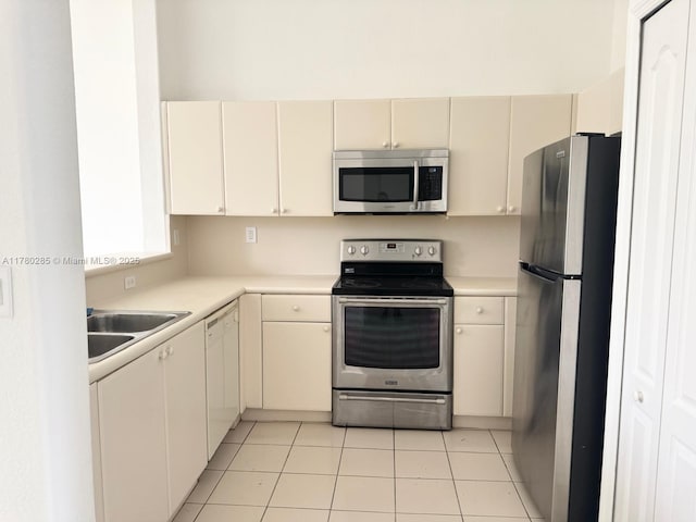 2524 SE 16th Rd Unit 201, Homestead, FL 33035 - kitchen featuring light tile patterned floors, light countertops, cream cabinets, stainless steel appliances, and a sink