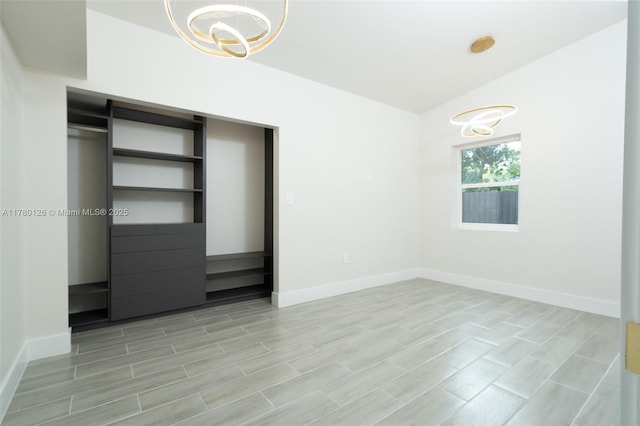unfurnished bedroom with baseboards, a chandelier, and lofted ceiling