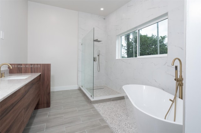 full bath with vanity, baseboards, recessed lighting, a marble finish shower, and a freestanding bath