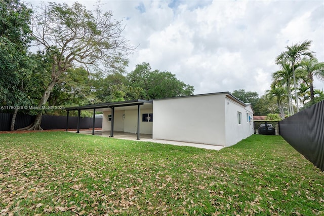 back of property featuring a patio, a yard, a fenced backyard, and stucco siding