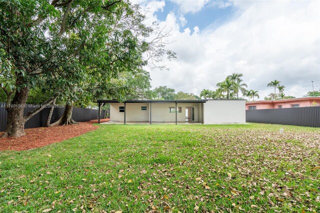 back of house featuring a patio area, a fenced backyard, and a lawn