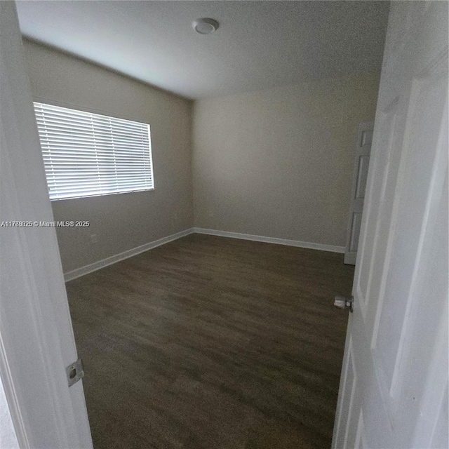 unfurnished room with wood finished floors and baseboards