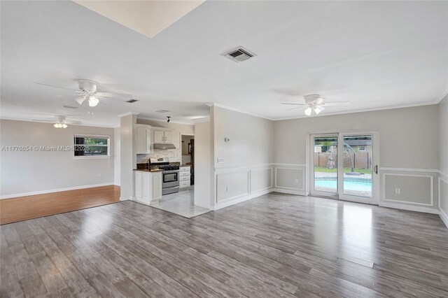 16395 SW 279th St, Homestead, FL 33031 - unfurnished living room featuring a ceiling fan, ornamental molding, light wood-style floors, a wainscoted wall, and baseboards