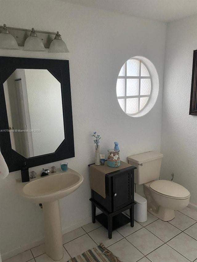 half bath with toilet and tile patterned flooring