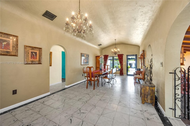 dining area with arched walkways, an inviting chandelier, baseboards, visible vents, and lofted ceiling