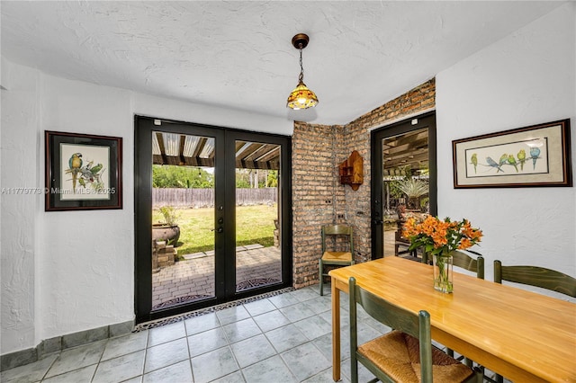 dining space with light tile patterned floors, french doors, and a textured ceiling