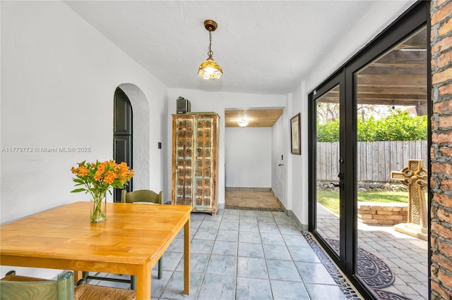 dining space with arched walkways and french doors