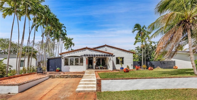 rear view of house with a pergola, a yard, stucco siding, and fence
