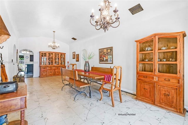 dining space featuring an inviting chandelier, marble finish floor, visible vents, vaulted ceiling, and arched walkways
