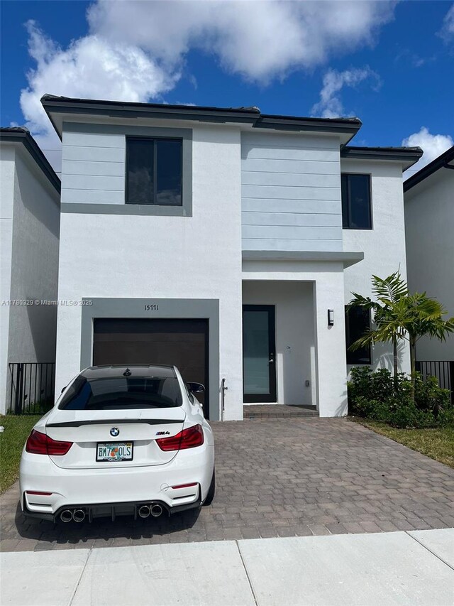15771 SW 136th Ter, Miami, FL 33196 - view of front facade featuring a garage, stucco siding, and decorative driveway