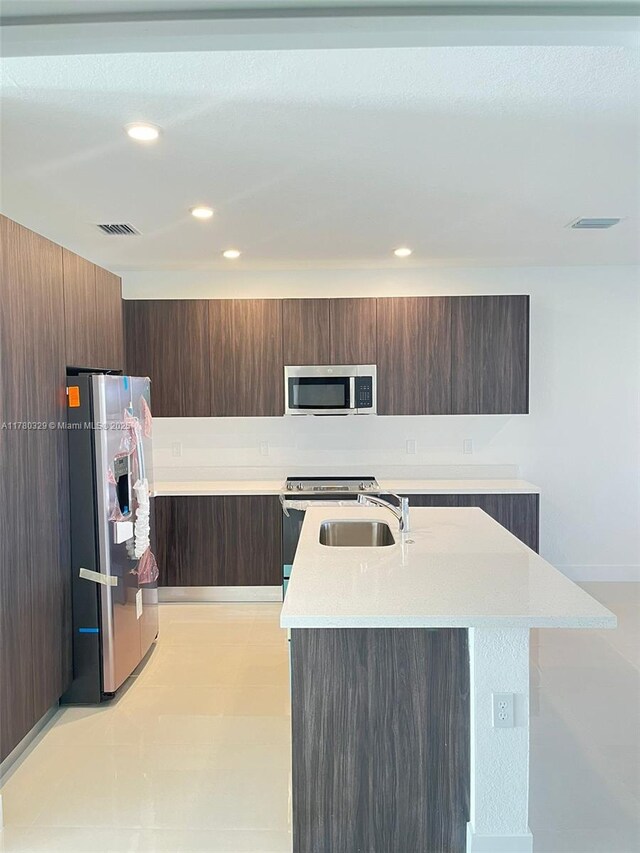 15771 SW 136th Ter, Miami, FL 33196 - kitchen featuring modern cabinets, a sink, light countertops, a kitchen island with sink, and stainless steel appliances