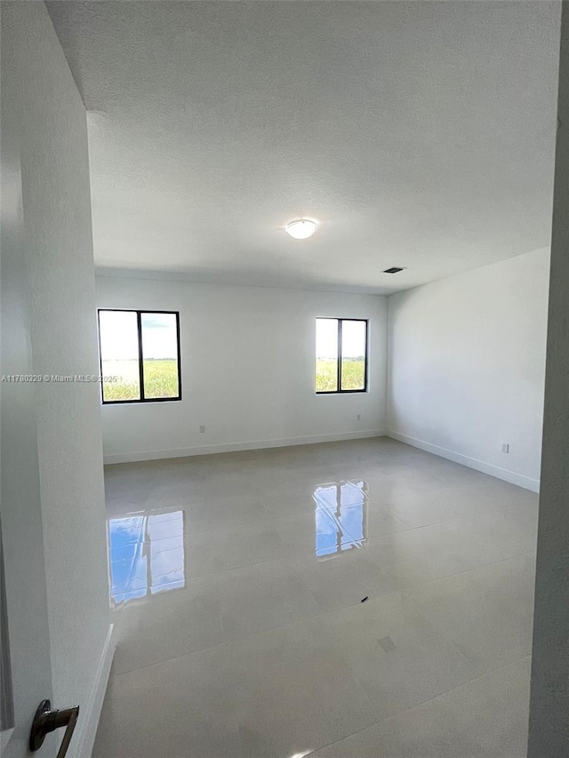 15771 SW 136th Ter, Miami, FL 33196 - tiled spare room featuring visible vents, baseboards, and a textured ceiling