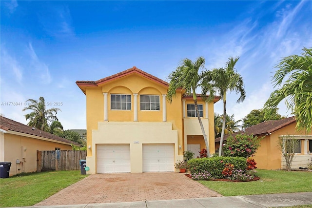 view of front of property featuring a garage, fence, stucco siding, a front lawn, and decorative driveway