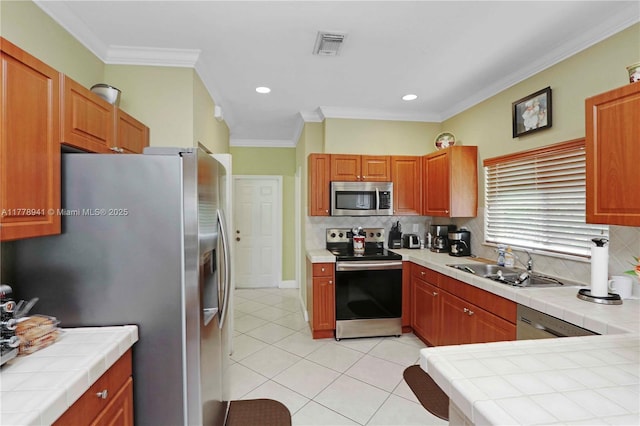 kitchen with tile countertops, light tile patterned floors, visible vents, appliances with stainless steel finishes, and a sink