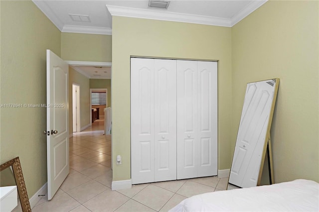 bedroom with light tile patterned floors, visible vents, baseboards, and ornamental molding