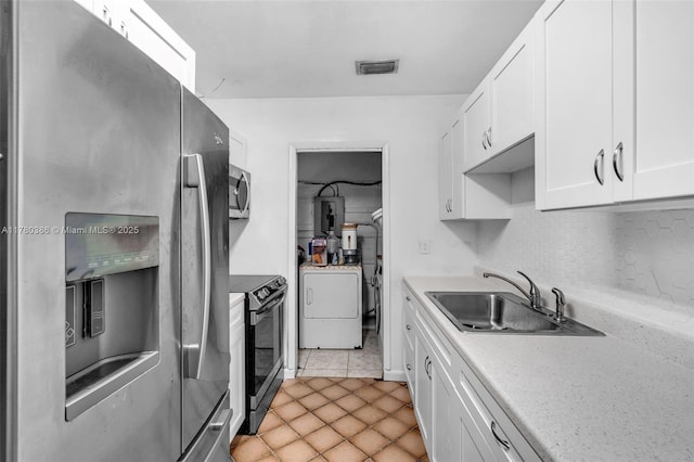 1271 NE 211th St, Miami, FL 33179 - kitchen featuring visible vents, a sink, white cabinets, washer / dryer, and stainless steel appliances