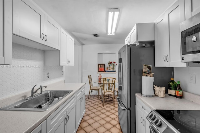 1271 NE 211th St, Miami, FL 33179 - kitchen featuring light countertops, a sink, white cabinetry, and stainless steel appliances