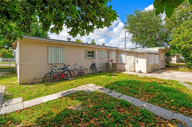 1271 NE 211th St, Miami, FL 33179 - rear view of house with fence, stucco siding, and a yard