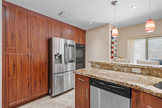 3663 SW 150th Ct, Miami, FL 33185 - kitchen featuring appliances with stainless steel finishes, brown cabinetry, decorative light fixtures, light stone countertops, and a textured ceiling