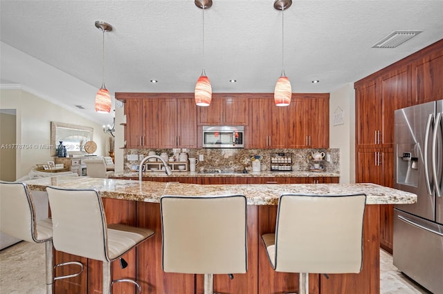 3663 SW 150th Ct, Miami, FL 33185 - kitchen with appliances with stainless steel finishes, tasteful backsplash, brown cabinets, light stone counters, and a textured ceiling