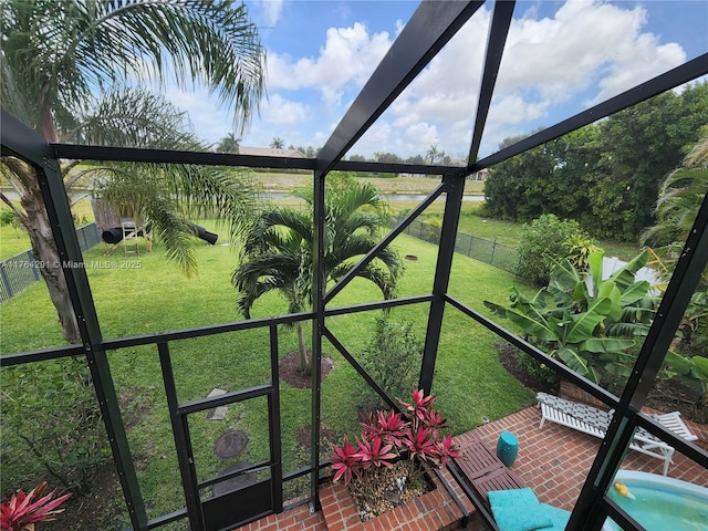 sunroom featuring a water view