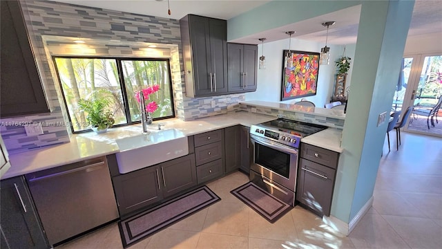 kitchen with a sink, light countertops, backsplash, and appliances with stainless steel finishes