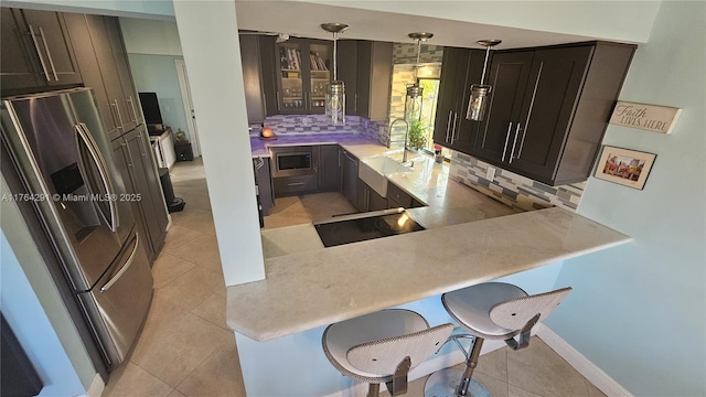kitchen featuring light countertops, a sink, backsplash, and appliances with stainless steel finishes