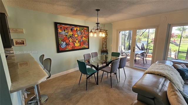 dining room featuring a chandelier, light tile patterned floors, a textured ceiling, and baseboards