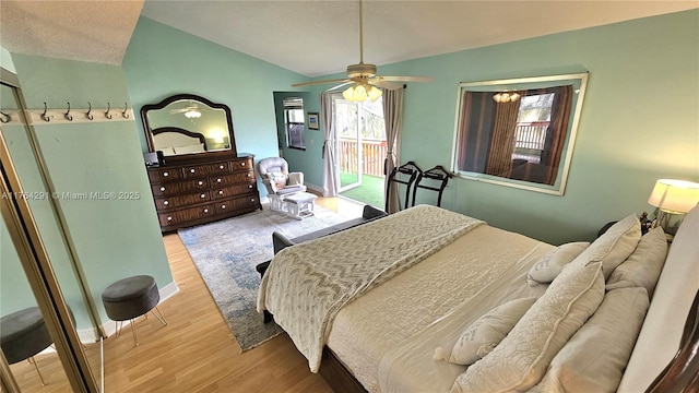 bedroom with access to exterior, vaulted ceiling, ceiling fan, and wood finished floors