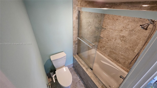 bathroom with tiled shower / bath combo and toilet