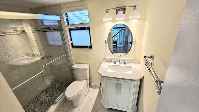 full bathroom featuring toilet, a stall shower, baseboards, and vanity