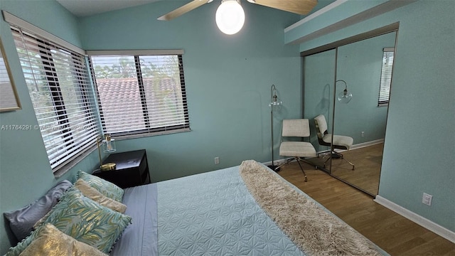 bedroom featuring baseboards, a closet, a ceiling fan, and wood finished floors