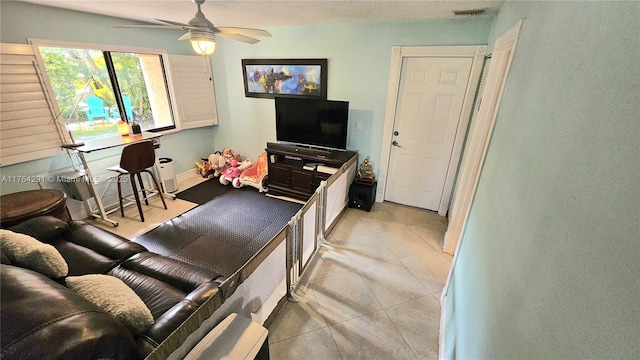 living room with light tile patterned floors, a ceiling fan, and visible vents