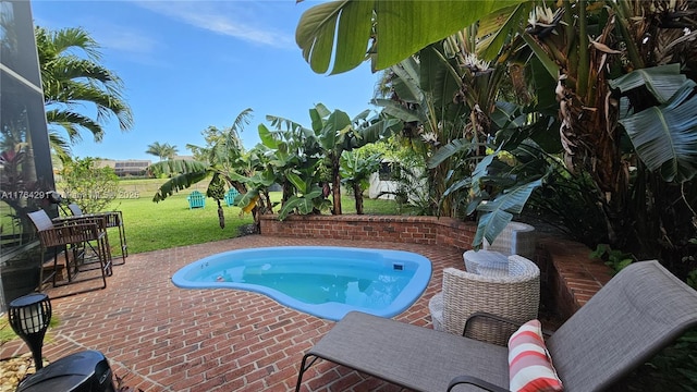 view of pool with a patio, a lawn, and a hot tub