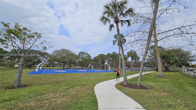 view of property's community featuring community basketball court and a yard