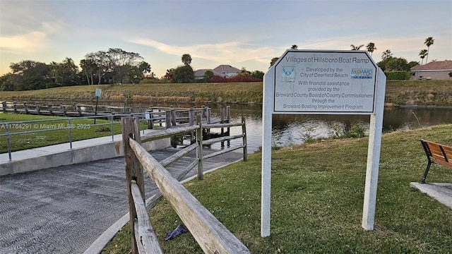 dock area with a water view and a lawn