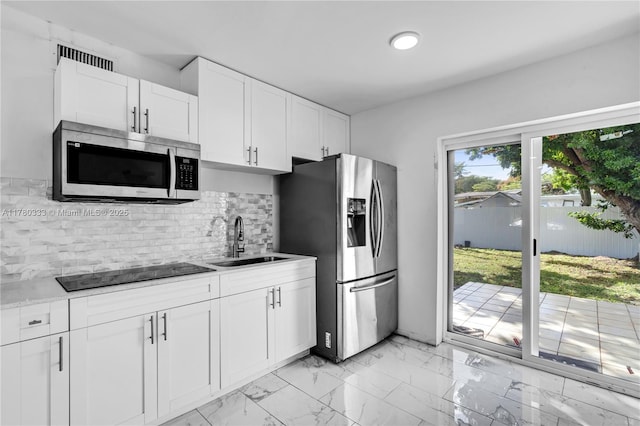 420 S 61st Ter, Hollywood, FL 33023 - kitchen with white cabinetry, marble finish floor, a sink, stainless steel appliances, and decorative backsplash
