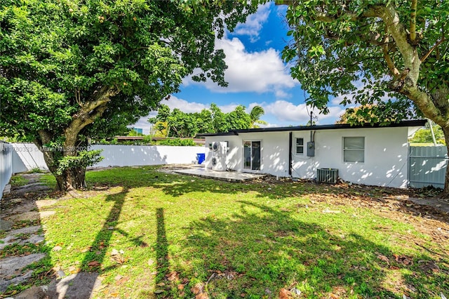 420 S 61st Ter, Hollywood, FL 33023 - rear view of house featuring a fenced backyard, stucco siding, a lawn, and central AC