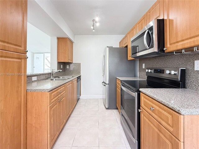 4756 NW 97th Ct Unit 79, Doral, FL 33178 - kitchen featuring tasteful backsplash, baseboards, light tile patterned flooring, stainless steel appliances, and a sink