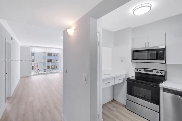 kitchen with white cabinetry, appliances with stainless steel finishes, light countertops, baseboards, and light wood-type flooring