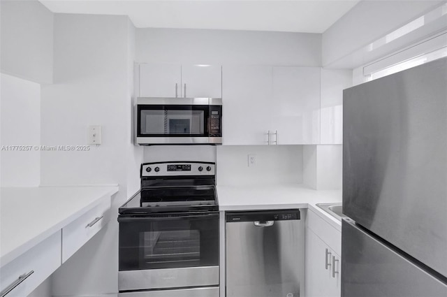 kitchen featuring light countertops, modern cabinets, appliances with stainless steel finishes, and white cabinetry