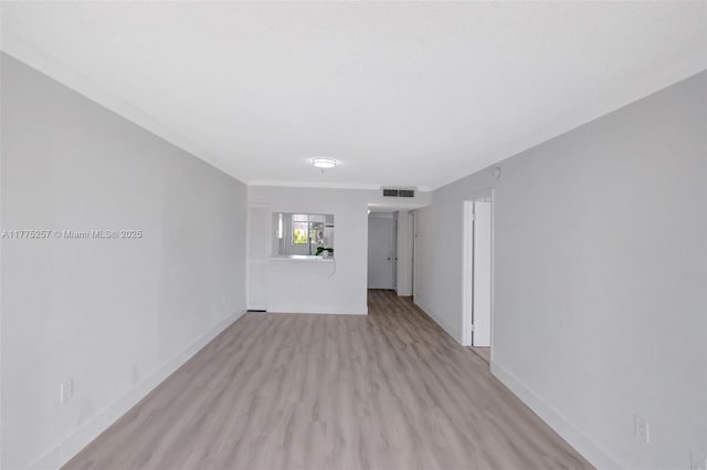 empty room featuring baseboards, visible vents, and light wood-style floors