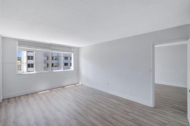 empty room featuring wood finished floors and baseboards