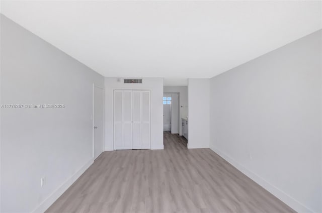 unfurnished bedroom with visible vents, light wood-type flooring, a closet, and baseboards