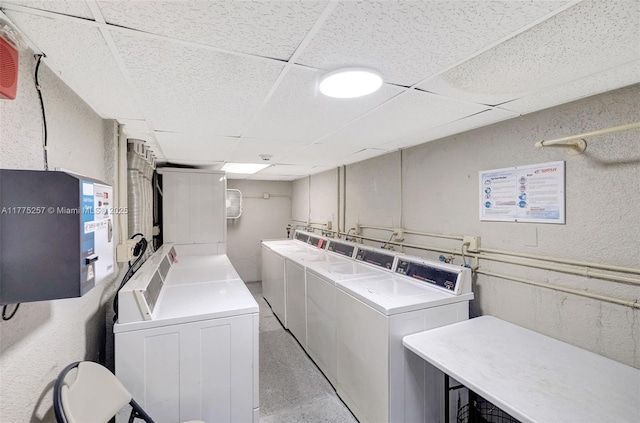 community laundry room with a textured wall and washing machine and dryer