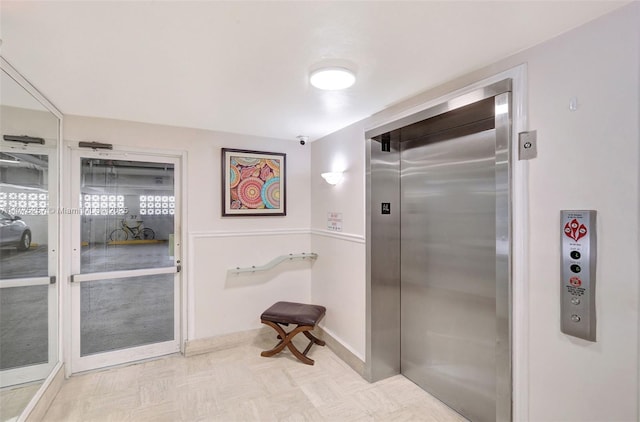 interior space featuring baseboards and elevator