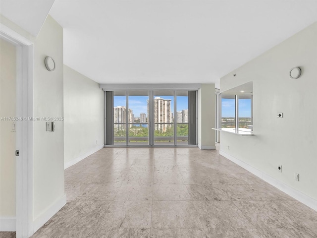 7000 Island Blvd Unit 1208, Aventura, FL 33160 - empty room featuring healthy amount of natural light, a city view, and a wall of windows