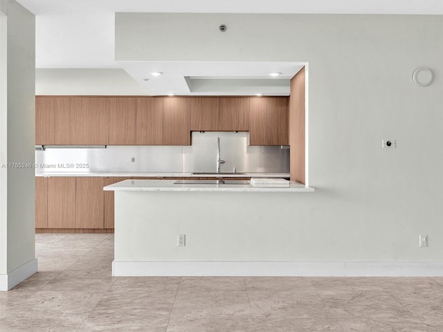 7000 Island Blvd Unit 1208, Aventura, FL 33160 - kitchen with light countertops, brown cabinetry, modern cabinets, a peninsula, and recessed lighting