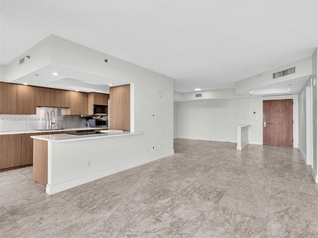 7000 Island Blvd Unit 1208, Aventura, FL 33160 - kitchen featuring modern cabinets, brown cabinets, light countertops, recessed lighting, and open floor plan